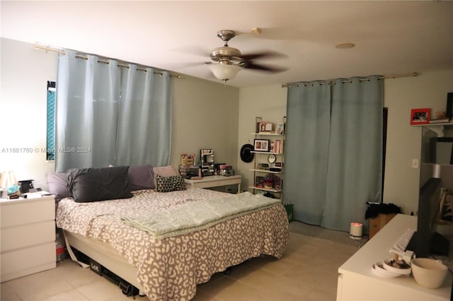 tiled bedroom featuring ceiling fan