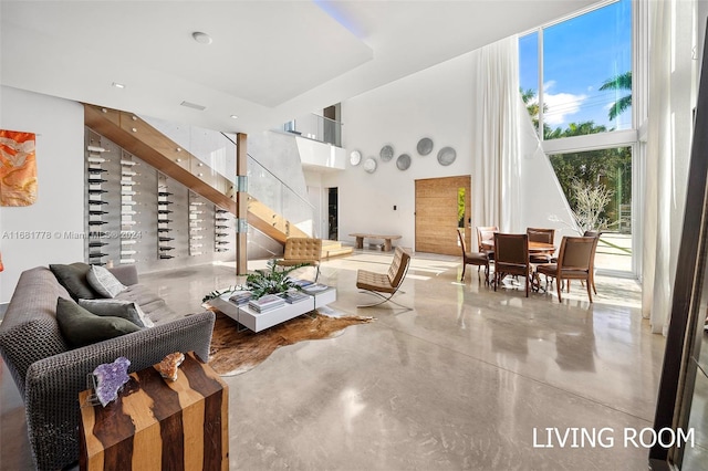 living room featuring concrete floors and a high ceiling