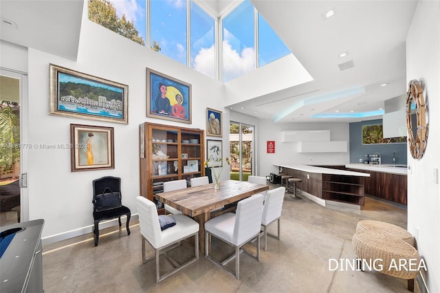 dining room featuring sink and a towering ceiling