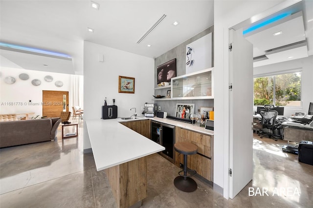 bar featuring concrete floors, wine cooler, and sink