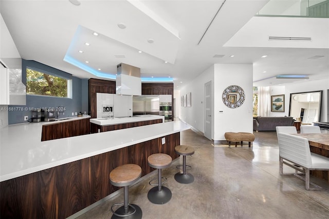 kitchen featuring a breakfast bar, sink, appliances with stainless steel finishes, concrete floors, and a kitchen island