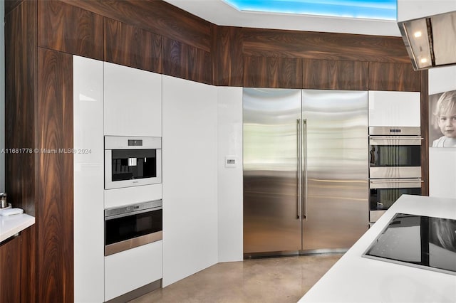 kitchen with dark brown cabinets, stainless steel appliances, and white cabinetry