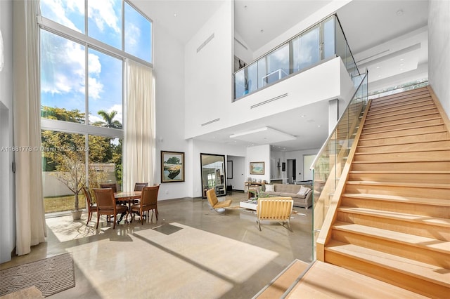 living room featuring a high ceiling and concrete floors