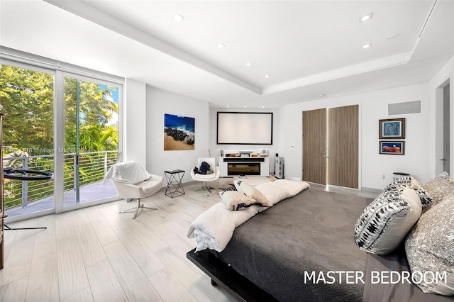 bedroom featuring a raised ceiling and access to exterior