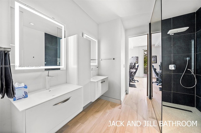 bathroom with hardwood / wood-style flooring, vanity, and walk in shower