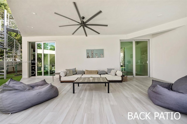 living room with light hardwood / wood-style flooring and ceiling fan