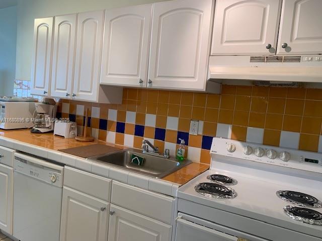 kitchen with white appliances and white cabinets