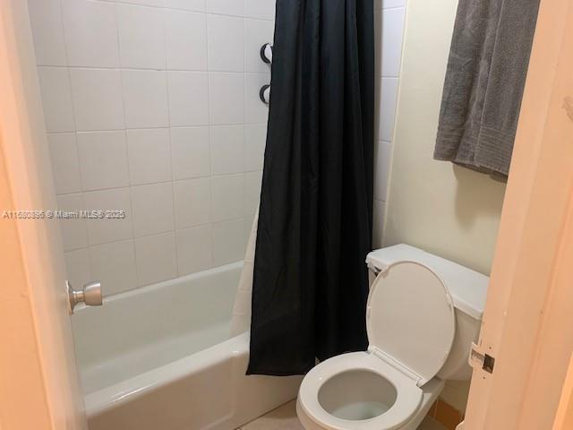 bathroom with shower / bath combo with shower curtain and toilet