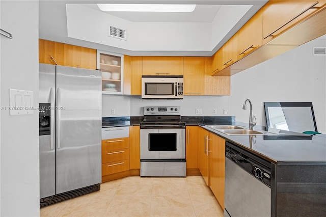 kitchen with appliances with stainless steel finishes, sink, and light tile patterned floors