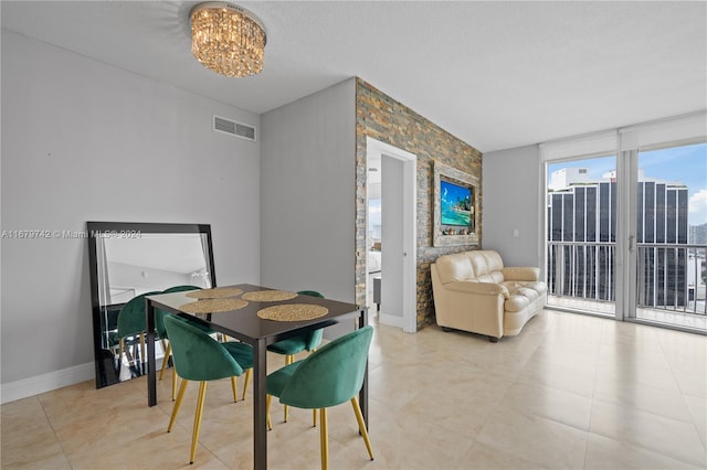 tiled dining area with a notable chandelier and a textured ceiling