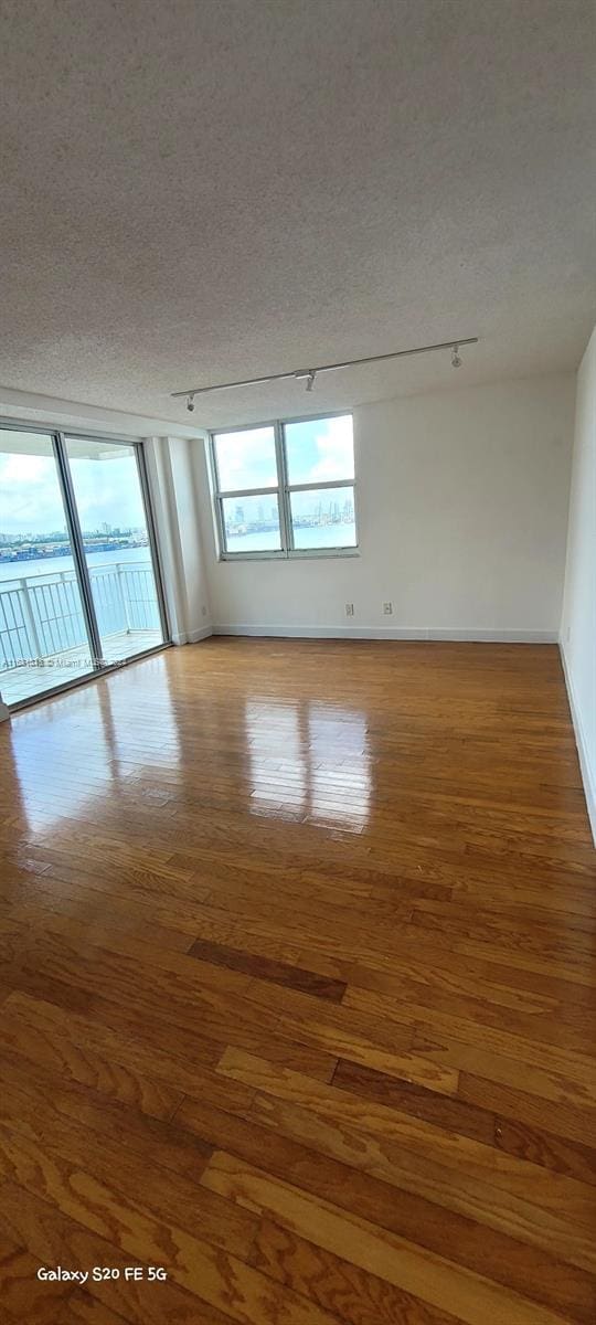 unfurnished room featuring a textured ceiling and wood-type flooring