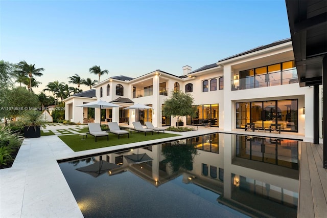 pool at dusk with a patio