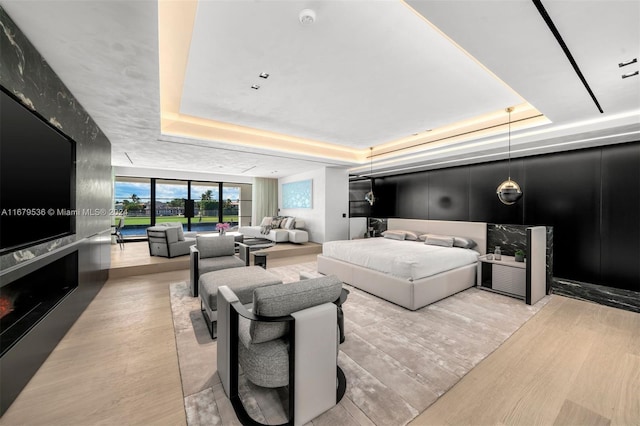 bedroom featuring light hardwood / wood-style floors and a tray ceiling