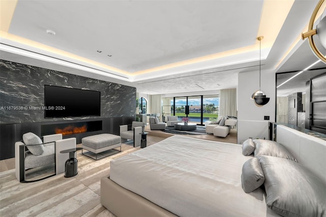 bedroom with a fireplace and a raised ceiling