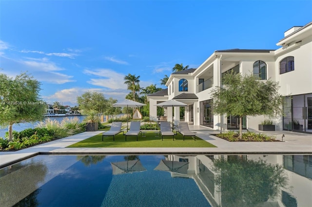 view of swimming pool with a yard and a water view