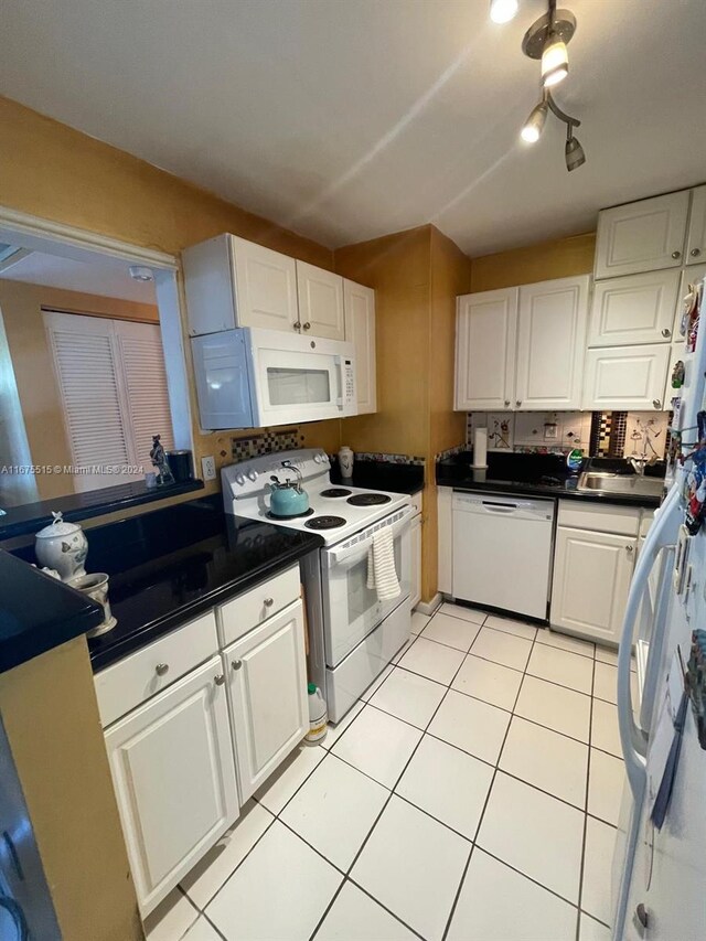 kitchen with sink, white cabinets, and white appliances