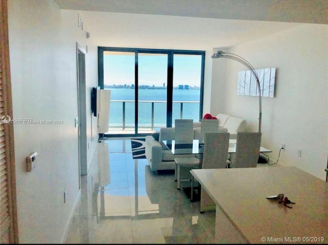 tiled living room featuring a water view