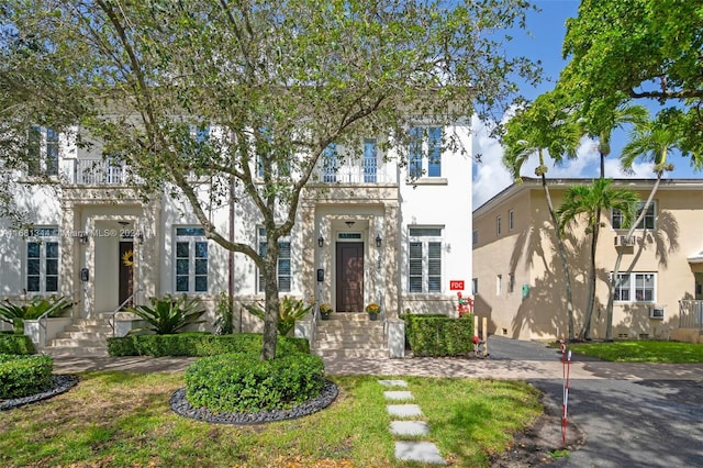 view of front of house with a front yard and a balcony