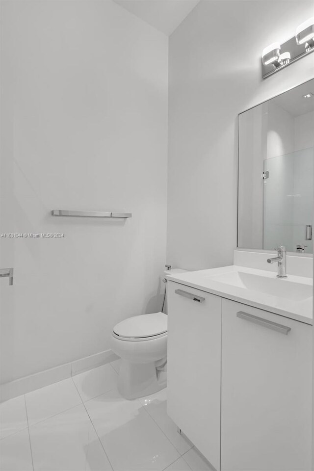 bathroom with vanity, toilet, and tile patterned floors