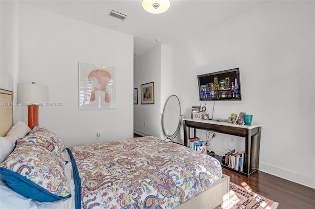 bedroom with dark hardwood / wood-style floors