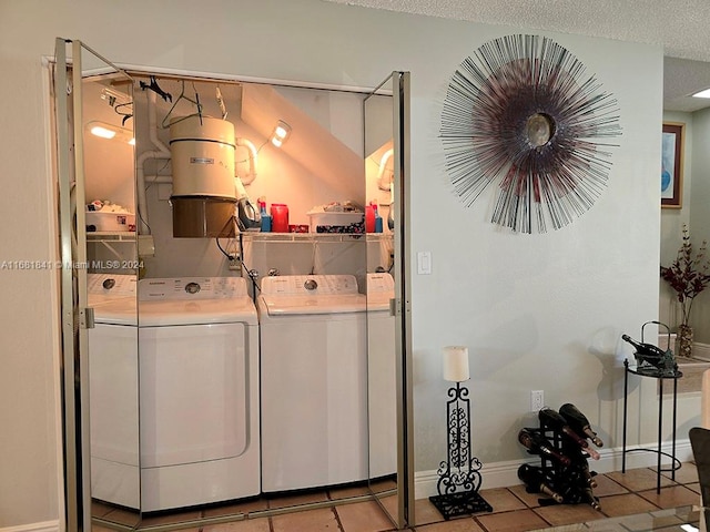 clothes washing area with light tile patterned floors, a textured ceiling, and independent washer and dryer