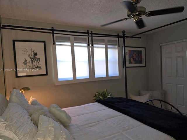 bedroom with a textured ceiling and ceiling fan