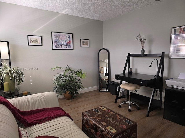 office area with hardwood / wood-style floors, lofted ceiling, and a textured ceiling