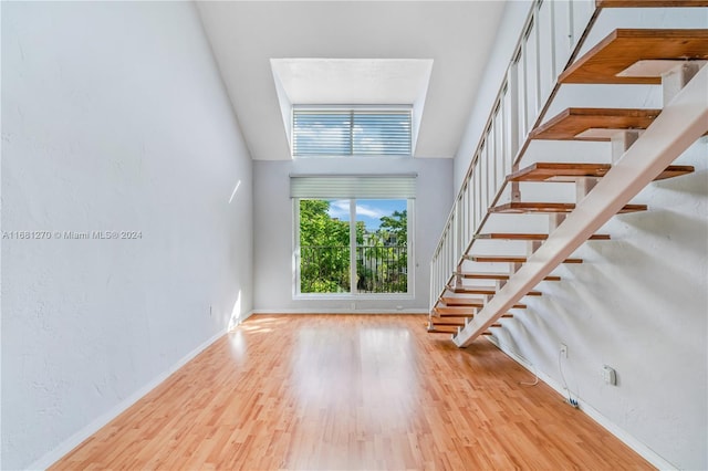 unfurnished living room featuring light hardwood / wood-style flooring and a high ceiling