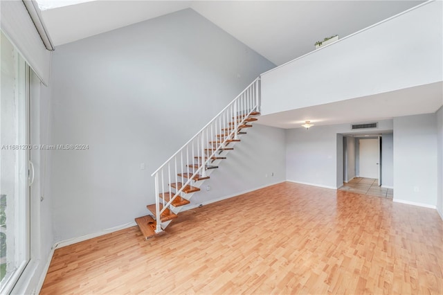 interior space with high vaulted ceiling and light hardwood / wood-style flooring