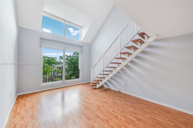 unfurnished living room featuring a towering ceiling and hardwood / wood-style floors