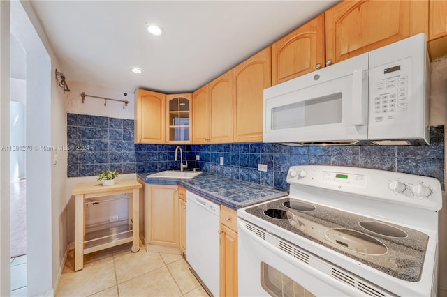 kitchen featuring decorative backsplash, light tile patterned floors, light brown cabinetry, sink, and white appliances