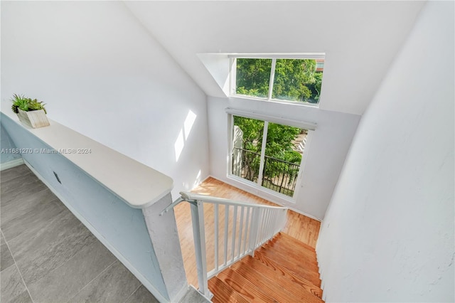 stairs with hardwood / wood-style floors and a high ceiling