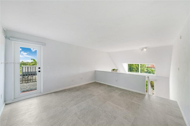 unfurnished room with lofted ceiling and plenty of natural light