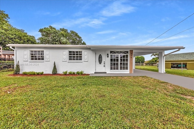 ranch-style house featuring a carport and a front yard