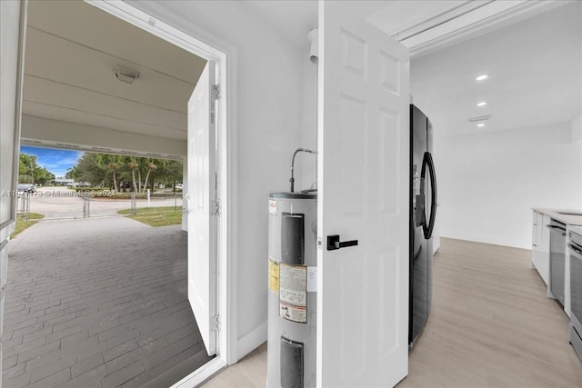 kitchen featuring black fridge, water heater, light hardwood / wood-style flooring, and dishwasher