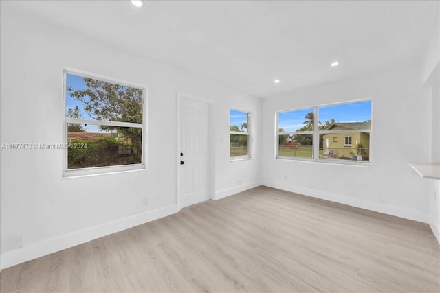 unfurnished living room featuring plenty of natural light and light hardwood / wood-style flooring