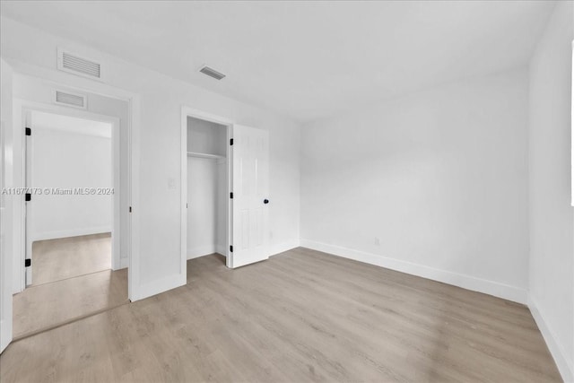 unfurnished bedroom featuring a closet and light hardwood / wood-style floors