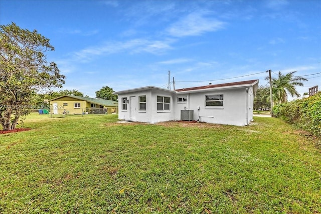 back of house featuring a yard and central AC unit