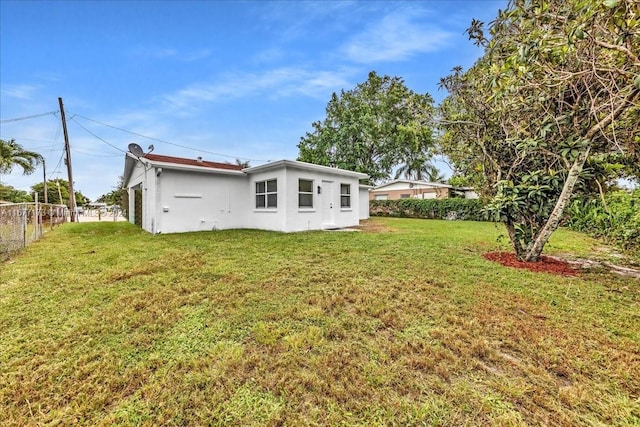 rear view of property featuring a lawn