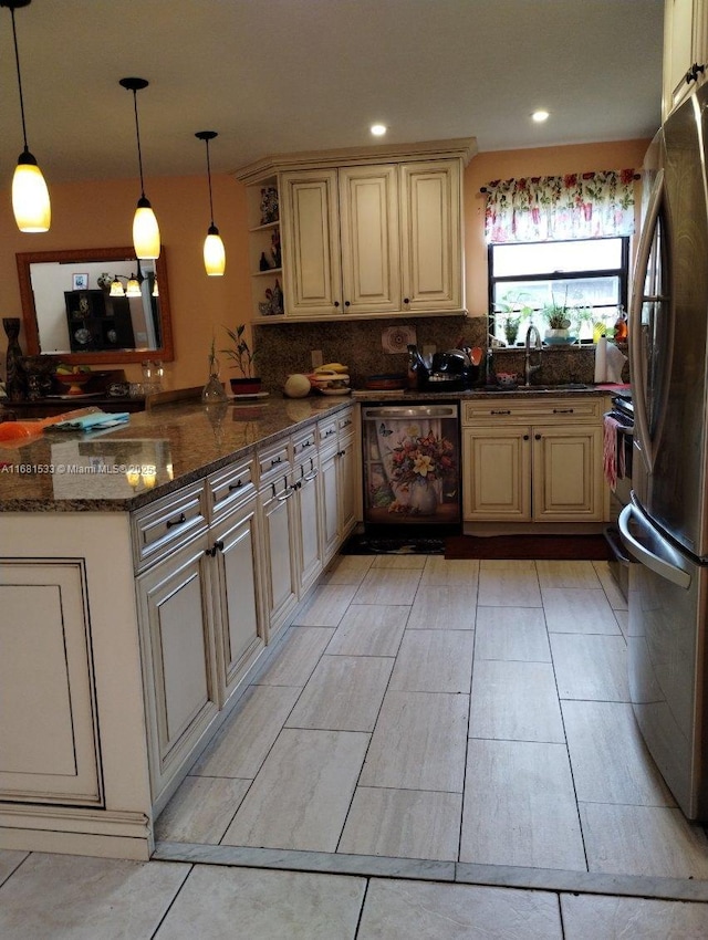 kitchen with appliances with stainless steel finishes, dark stone counters, sink, hanging light fixtures, and kitchen peninsula