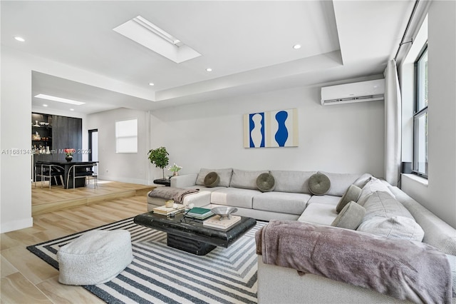 living room featuring a skylight, a wealth of natural light, a wall mounted air conditioner, and light wood-type flooring