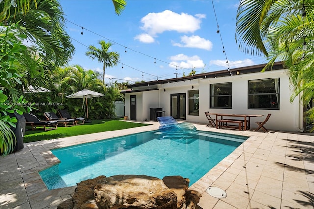 view of swimming pool featuring a patio area and a lawn