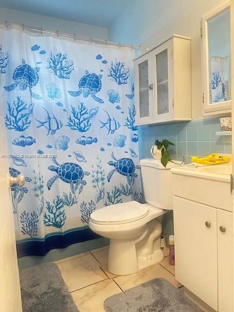 bathroom featuring vanity, toilet, tile patterned floors, and backsplash