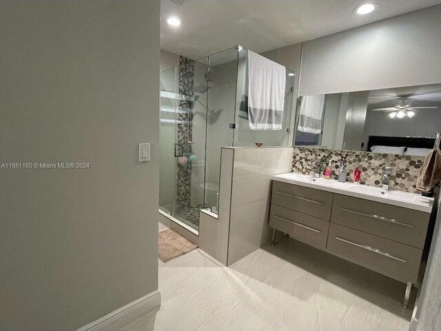 bathroom with a shower with door, vanity, decorative backsplash, and ceiling fan