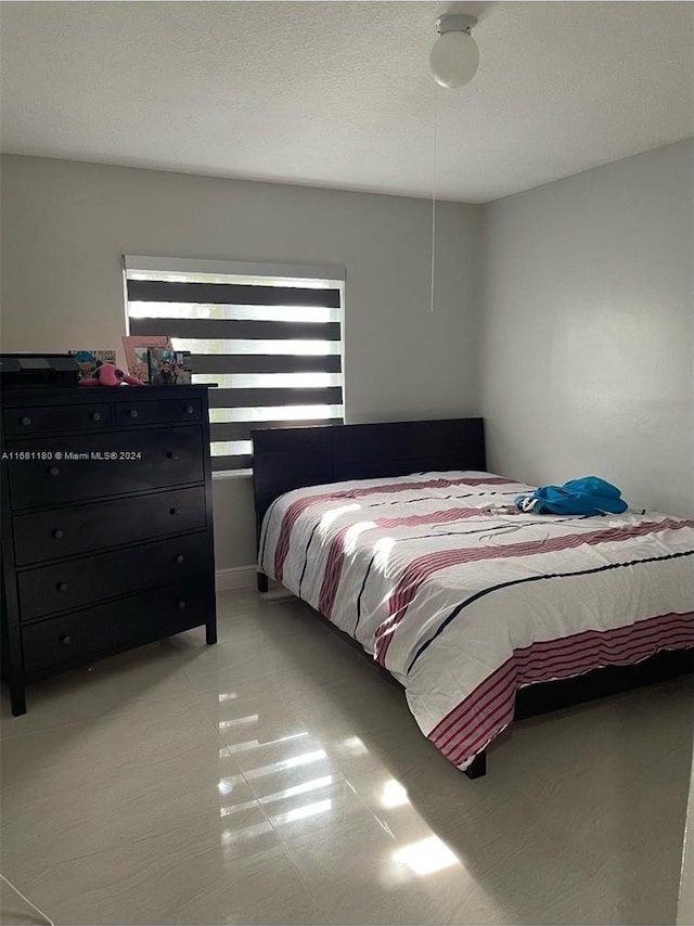 bedroom with a textured ceiling and ceiling fan