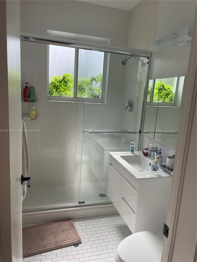 bathroom with an enclosed shower, vanity, a wealth of natural light, and tile patterned floors