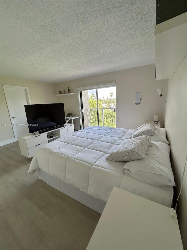 carpeted bedroom featuring access to exterior and a textured ceiling