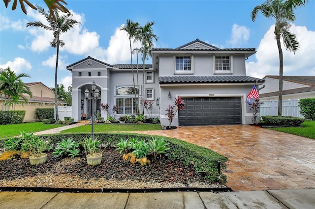 mediterranean / spanish-style house featuring a front yard and a garage