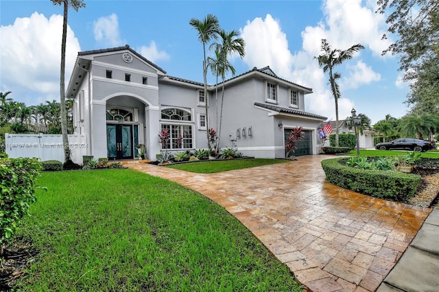 mediterranean / spanish home featuring a front lawn and a garage