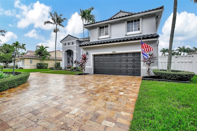 mediterranean / spanish house featuring a front yard and a garage